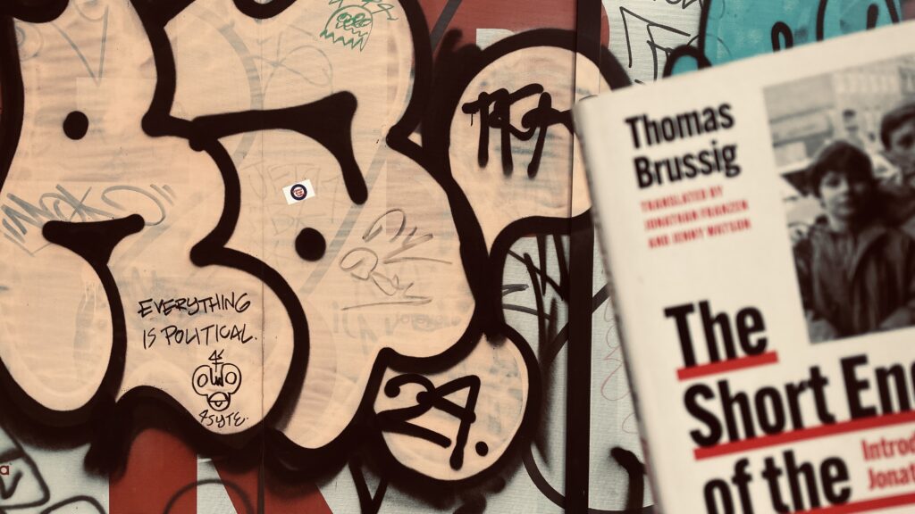 Colourful street graffiti with a hidden message scrawled in small letters that says 'everything is political'