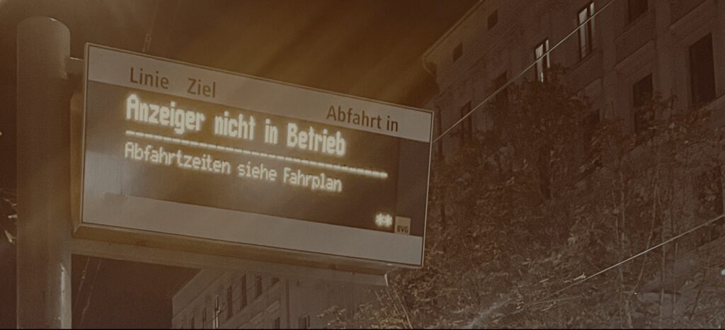 A malfunctioning bus stop display at night